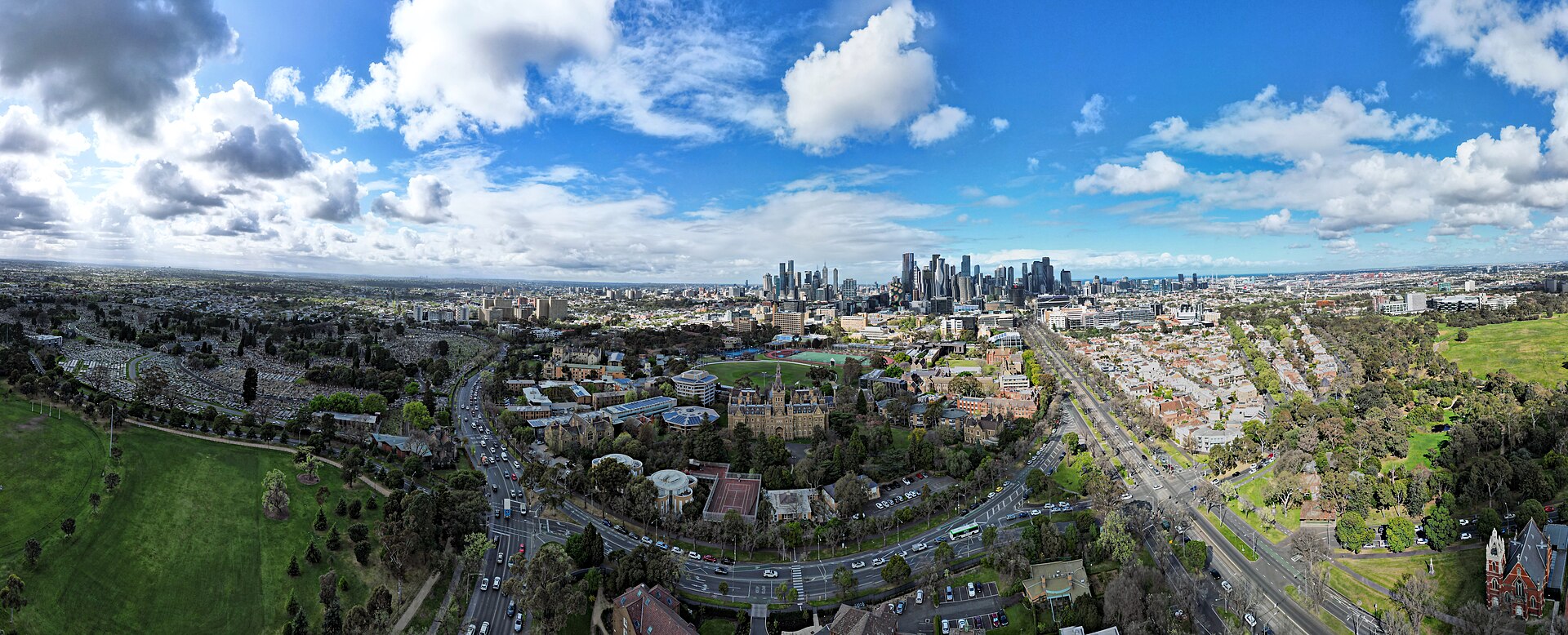 Aerial panorama of University of Melbourne facing the city skyline. September 2023.